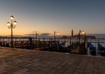 a dock with boats and a city in the background
